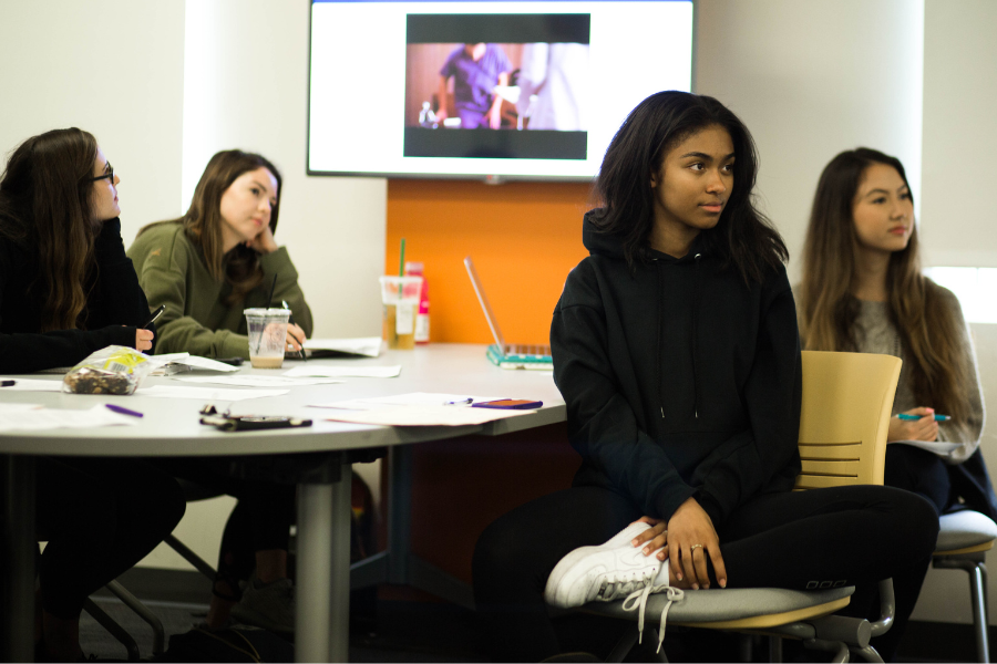 Four students sit in class and listen to a lecture at LMU